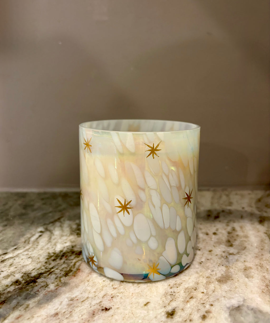 Candle with star pattern on a woven tray in a cozy living room setting